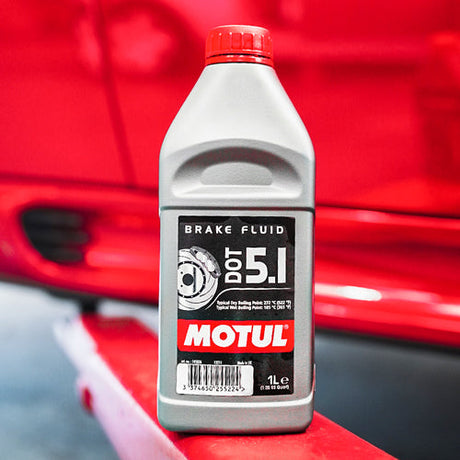 A Bottle of Motul DOT 5.1 brake fluid next to a Mini